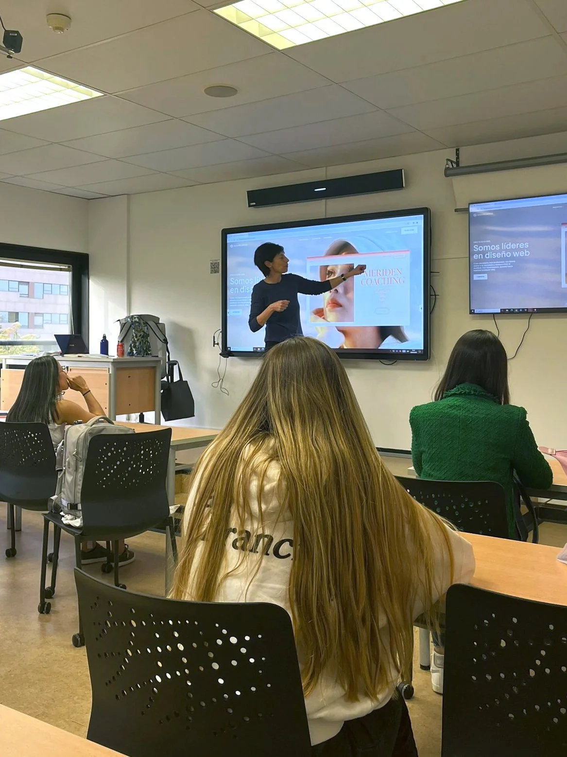 Pilar Gargallo impartiendo formacion en aula con alumnado de espaldas